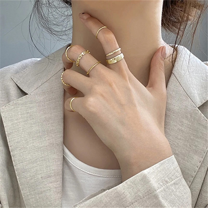 Woman in white outfit with hand on neck